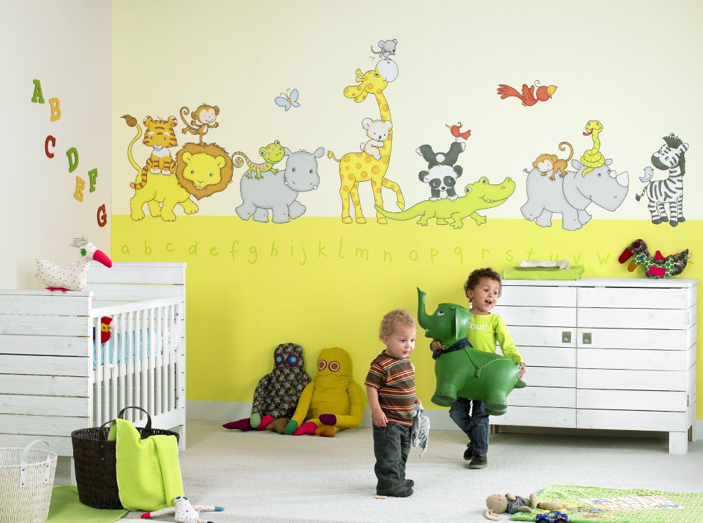 Trẻ mầm non trong phòng với bức tranh tường
