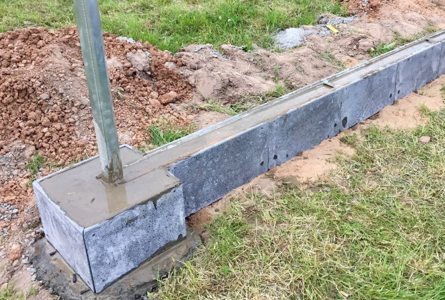 Concrete foundation for a fence with brick pillars