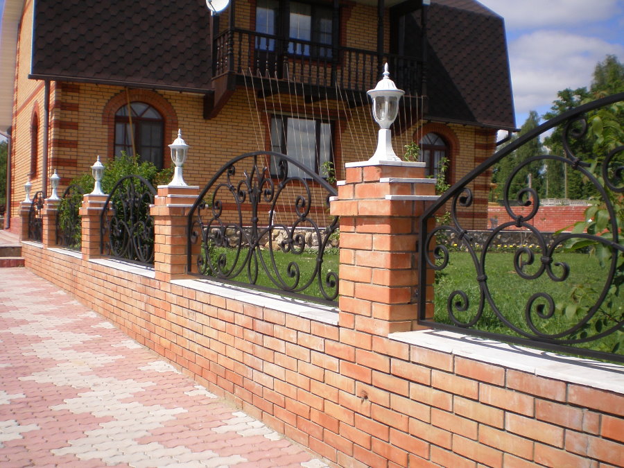 Forged fence sections with brick pillars