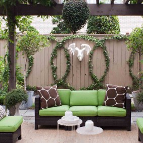 Yeşil yastık ile bahçe kanepe