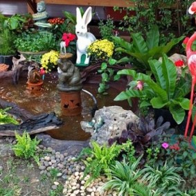 Sculpture of a pink flamingo in front of a pond