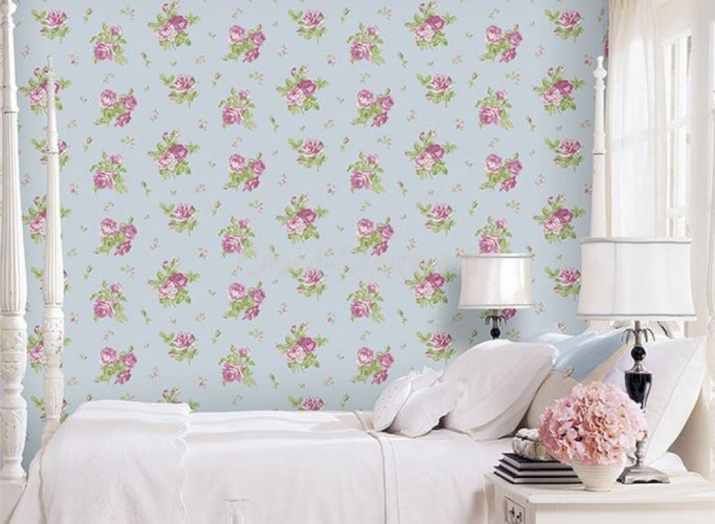 Kızın yatağının arkasındaki duvar kağıdı üzerinde küçük çiçekler