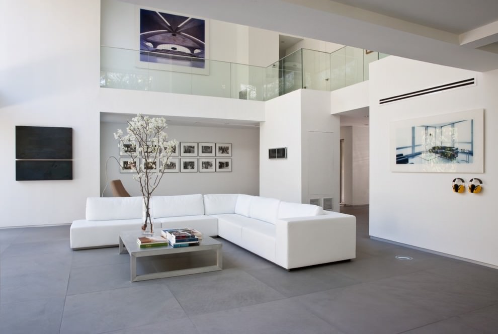 Stor vit soffa i ett rum i minimalistisk stil