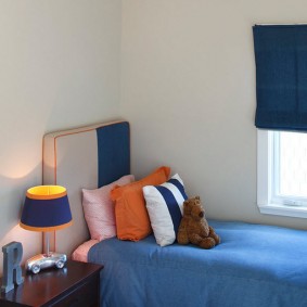 Oranža lampiņa virs zilas gultas