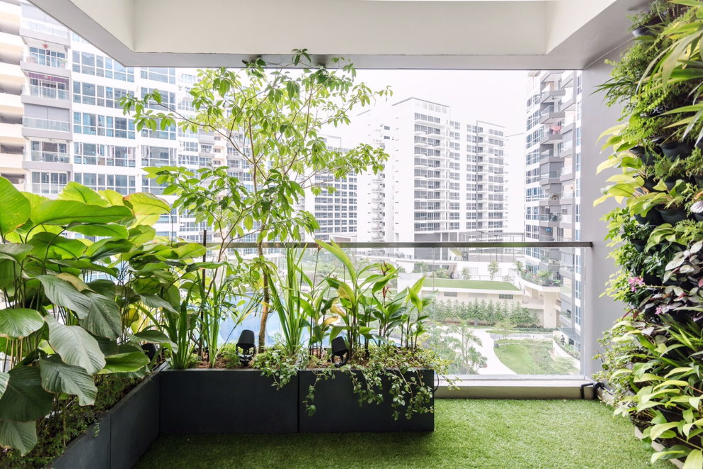 Zaļie augi uz daudzdzīvokļu mājas lodžijas