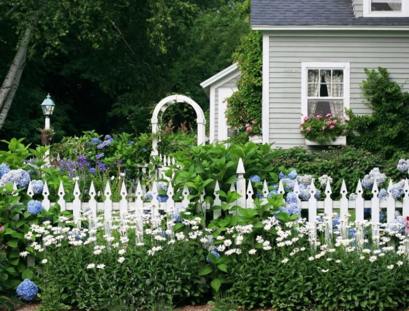 Il bianco recinta il giardino della parte anteriore del giardino