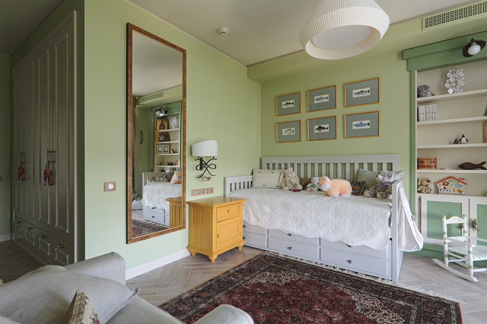 O oglindă mare pe peretele verde al camerei copiilor