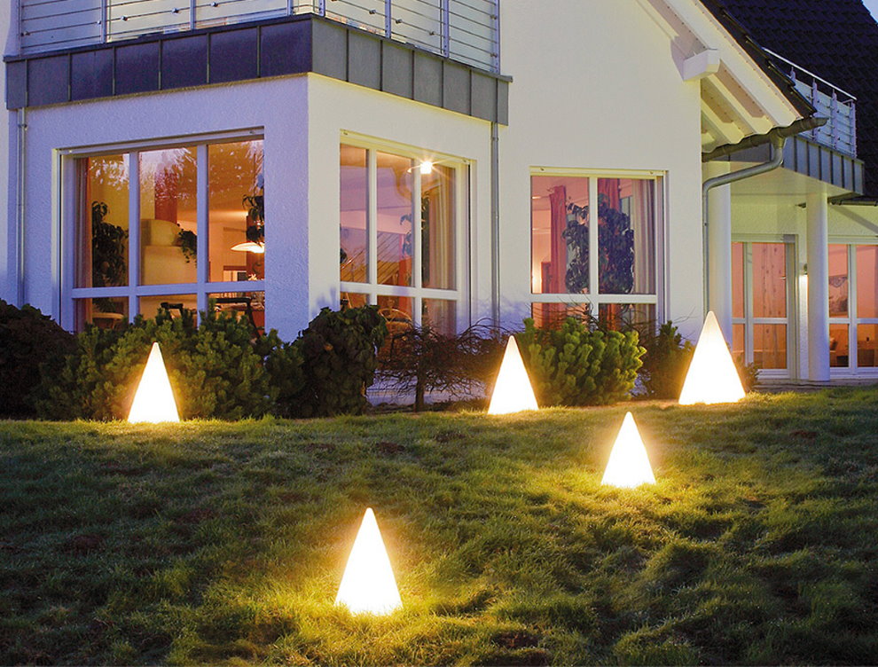 Evin önünde çimenlikte piramit lambalar