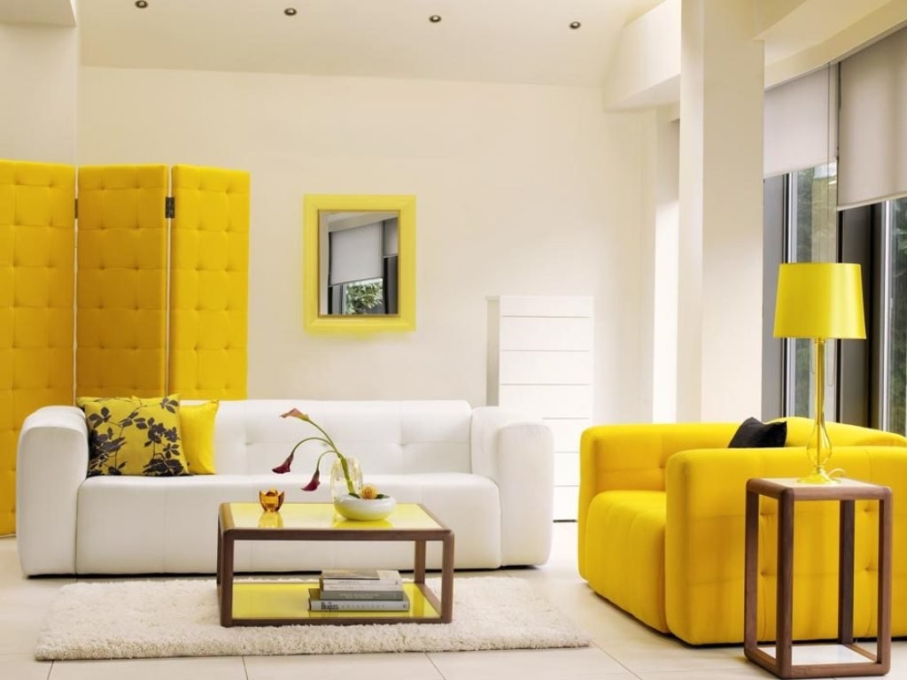 Màn hình màu vàng phía sau ghế sofa màu trắng