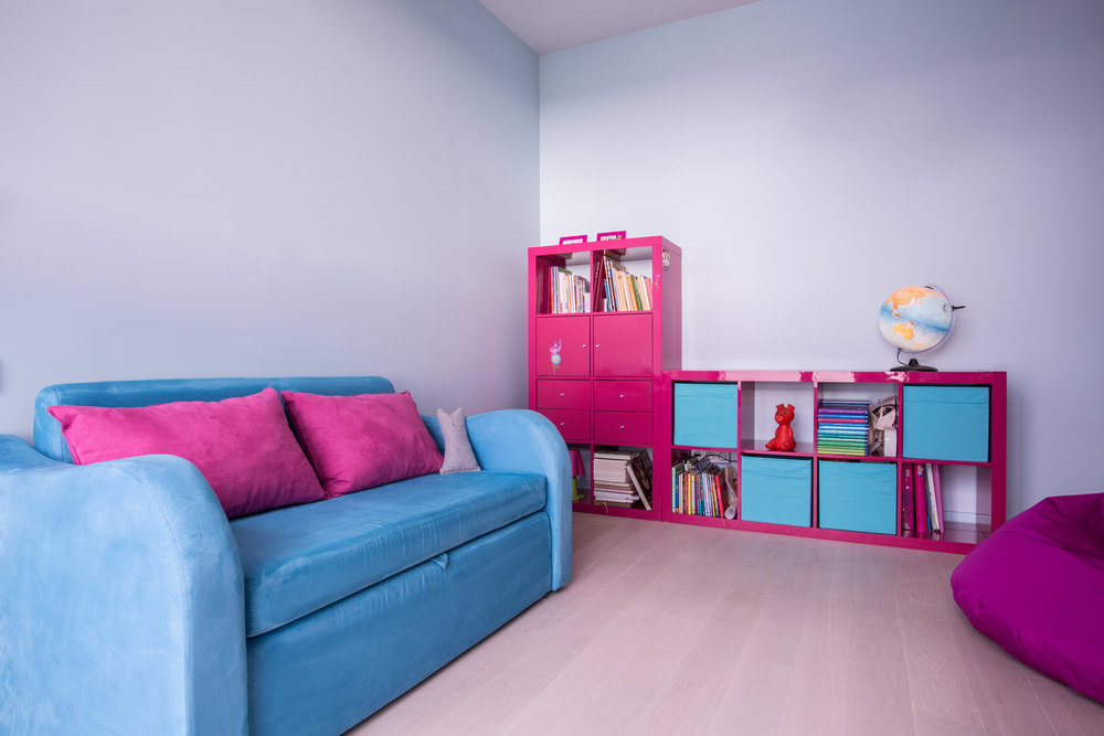 Roze en turquoise boekenkast met kinderspeelgoed