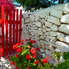 Portão vermelho em uma cerca de pedra