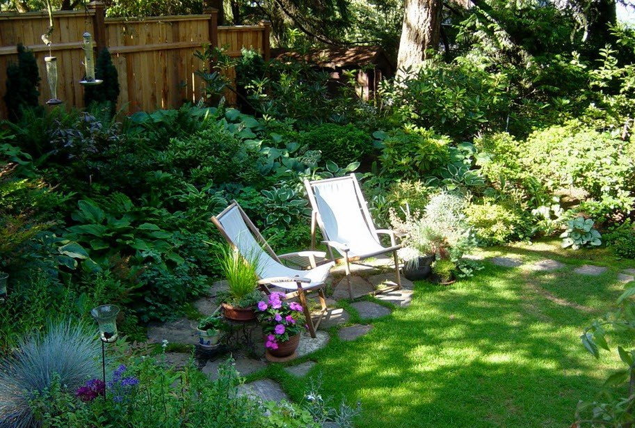 Șezlonguri de grădină într-un colț retras din grădină
