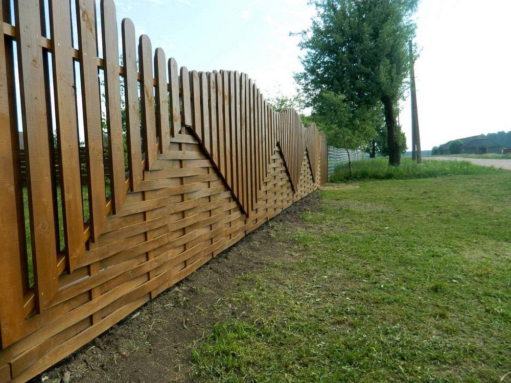 Wooden fence made of boards with different arrangement of shtaketin