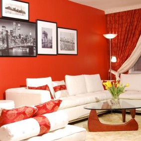 Balts dīvāns pret sarkano sienu
