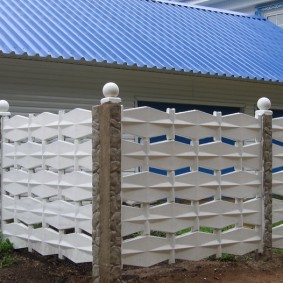 Bile albe pe stâlpii unui gard din beton
