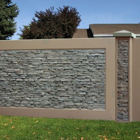 Față de un gard din beton cu piatră artificială