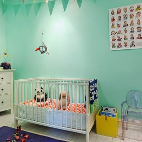 Wieg voor baby in de buurt van de turquoise muur