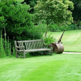 Wooden bench on a plot with garden and lawn