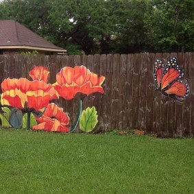 Farfalla e papaveri su un recinto di legno