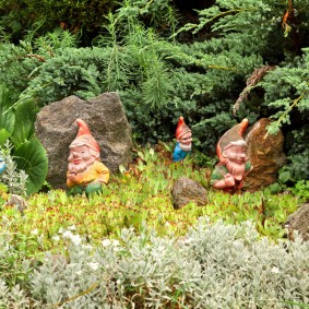 Ang mga gnome ng hardin sa ilalim ng mga conifer