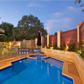 Outdoor pool on a plot with a wooden fence