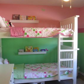 Pereți roz-verzi în spatele unui pat supraetajat