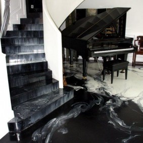 Grand piano đen trong hội trường với cầu thang