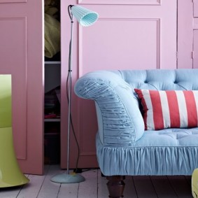 Kék kanapé egy szobában, rózsaszín falakkal