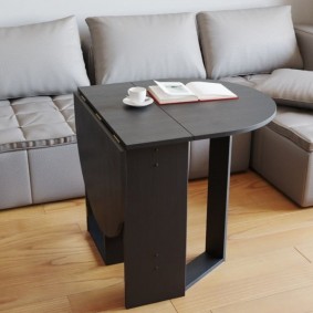 Schwarzer Tisch vor grauem Sofa