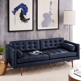 Pernas de madeira pelo sofá azul
