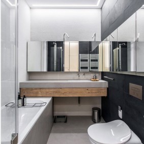 Smalt badkar med en spegel på väggen