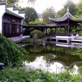 Oriental-style gazebo on the shore of a pond.