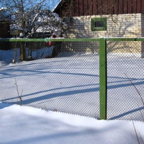 Green mesh fence in the winter at the cottage