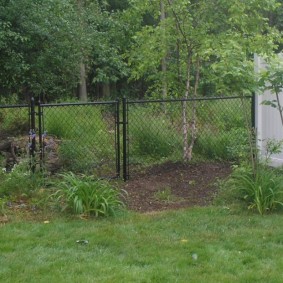 Góc của một ngôi nhà mùa hè với một hàng rào từ lưới