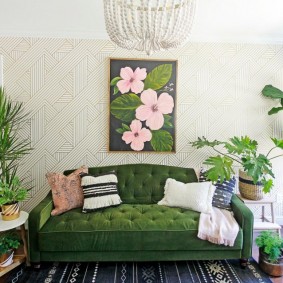 Một bảng điều khiển với hoa trên ghế sofa màu xanh lá cây