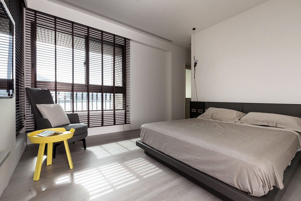 Scaun înalt galben într-un dormitor în stil minimalist.