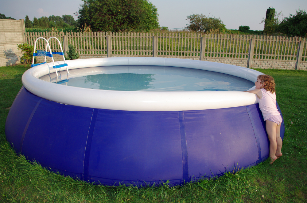 Maliit na bata sa gilid ng inflatable pool