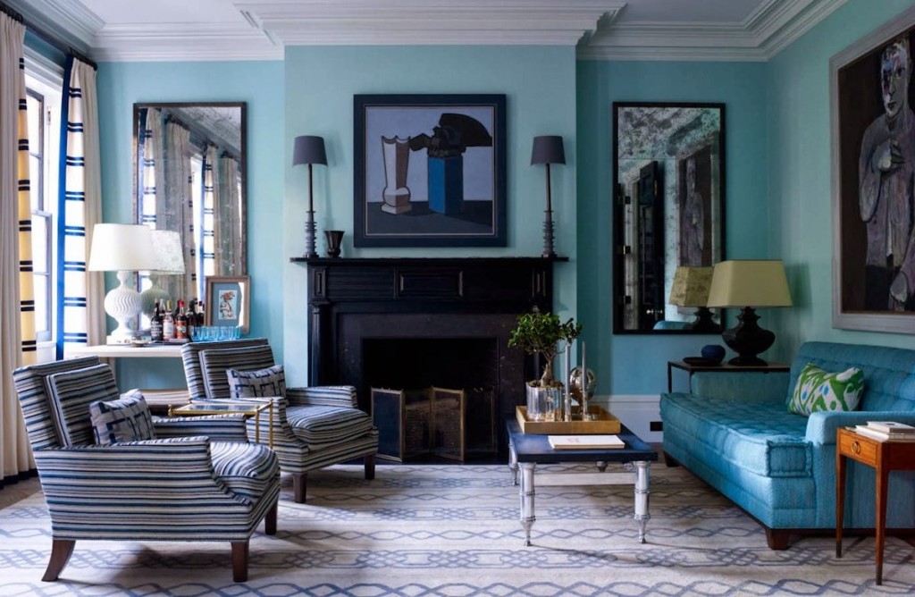 Czarny kominek w salonie z jasnoniebieską sofą