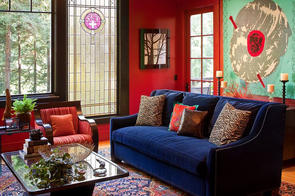 Sofá azul na sala de estar com paredes vermelhas