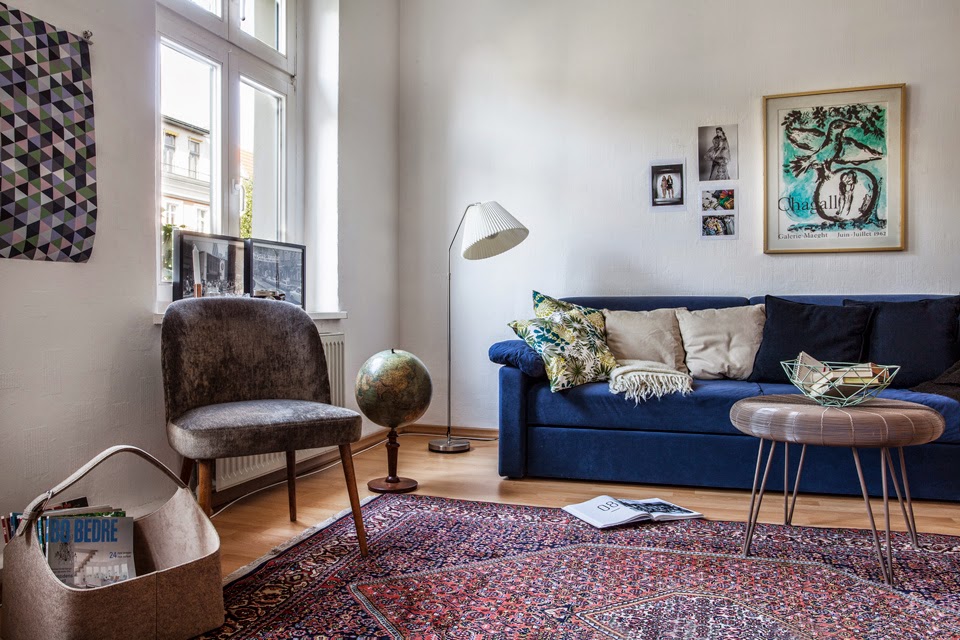 Lys stueutforming med en blå sofa