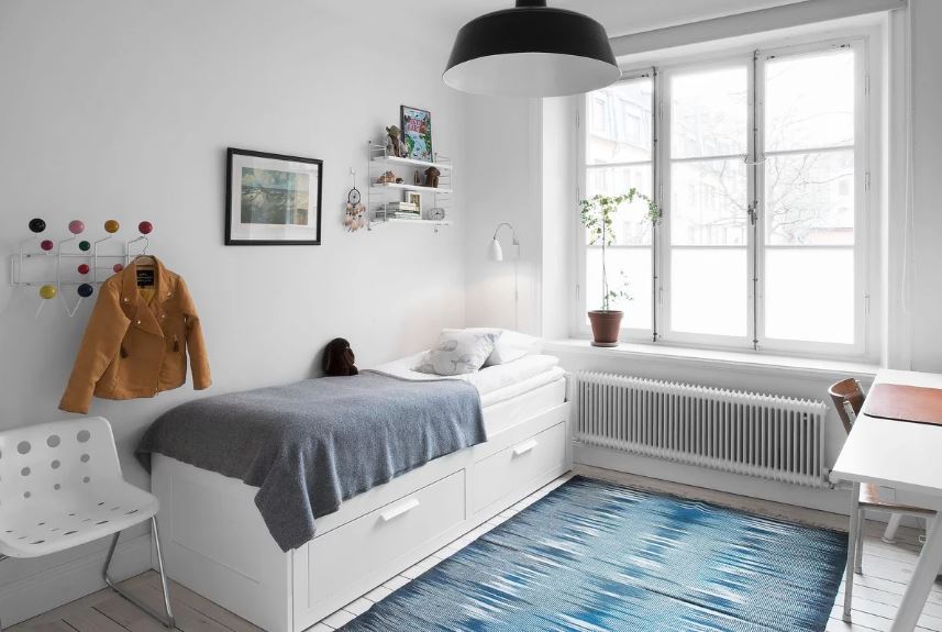 Bed with drawers in a white room