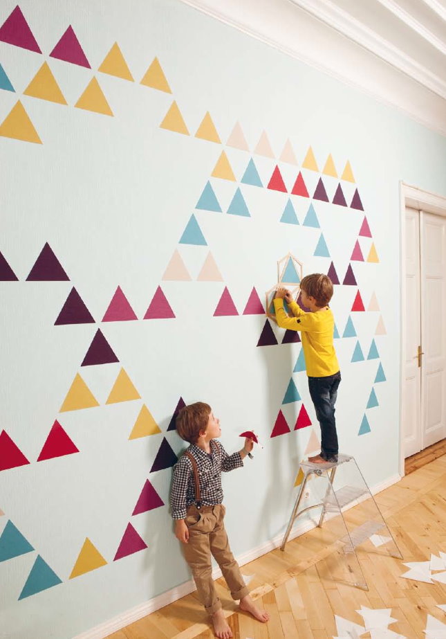 Koriste lastenhuoneen valkoisella seinällä, jossa on monivärisiä kolmioita