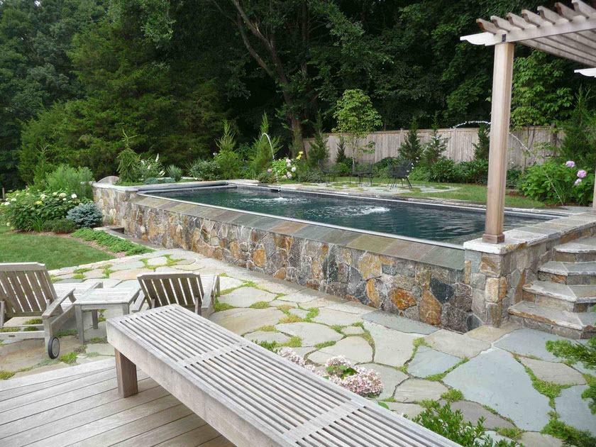 Narrow swimming pool with natural stone cladding