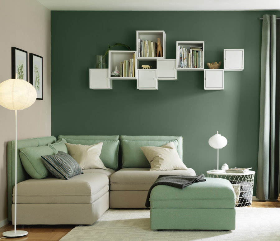 Prateleiras brancas em uma parede verde da sala de estar