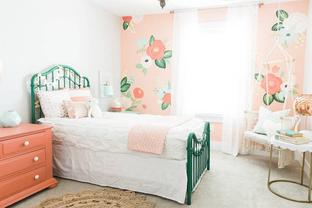 Grønn seng i det hvite soverommet til jenta