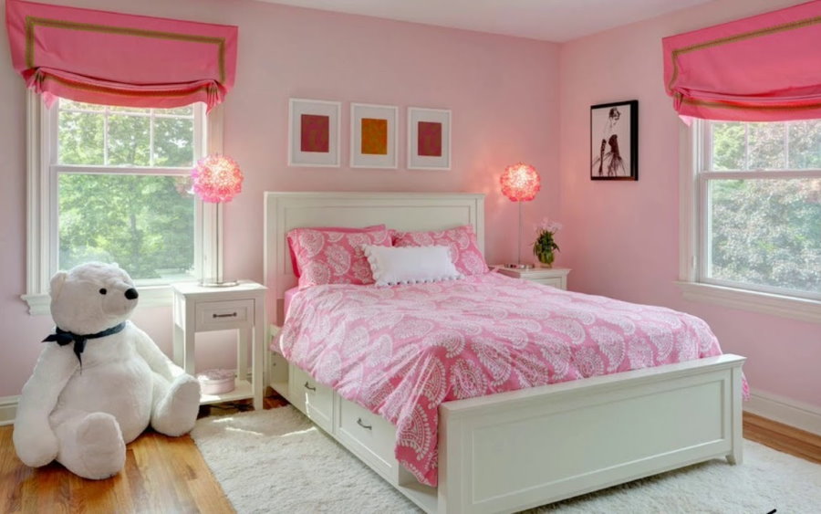 Vaaleanpunaiset verhot makuuhuoneessa, jossa valkoinen sänky.