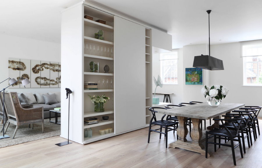 Zoning of the kitchen-living room with a white cabinet