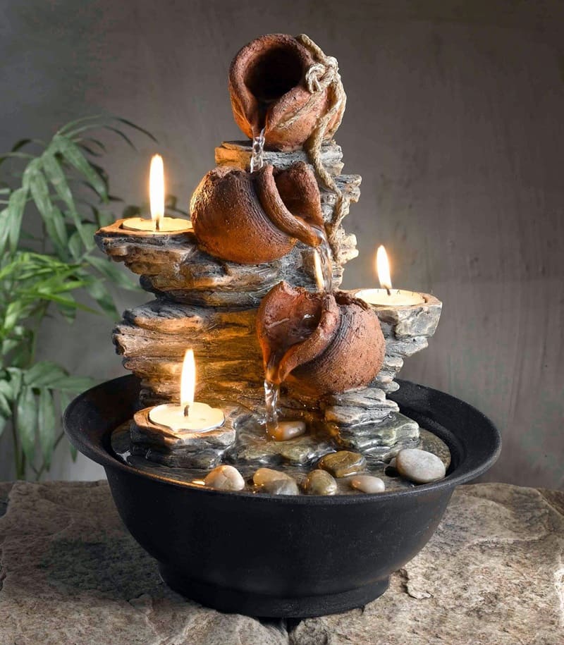 Fuente decorativa de piedra con velas