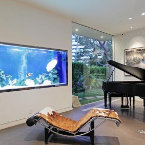 Ingebouwd aquarium in de kamer met een zwarte piano