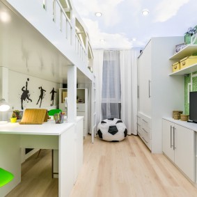 Habitación infantil pequeña con muebles blancos.